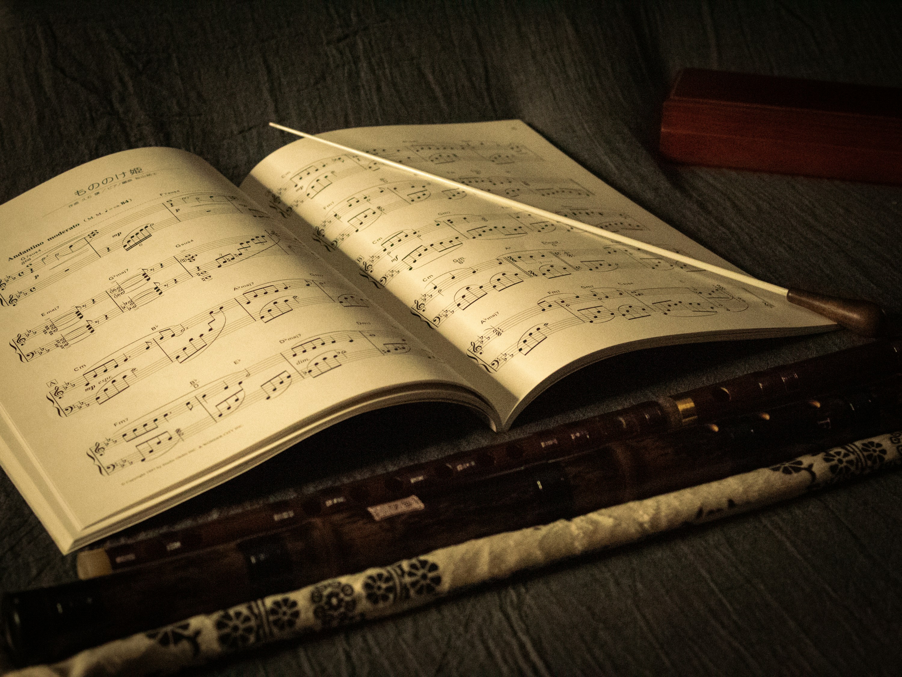 A sepia-toned musical score and baton on a conductor's stand, representing the choreography of teamwork